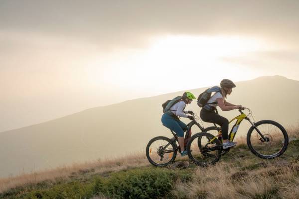 Two bikers riding up a mountain slope early in the morning in Taxas Hill Country