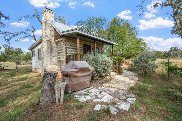 a small, primitive-style log cabin in texas hill country