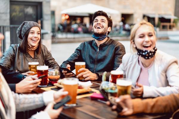 Friends laughing around a brewery table while enjoying a pint, Fredericksburg TX breweries