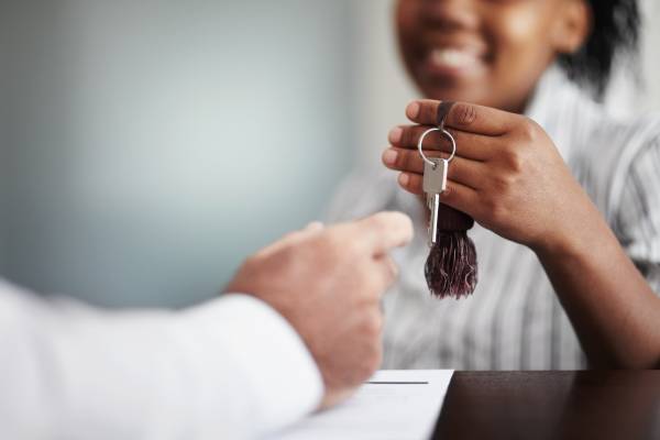 a woman hands over a house key in an office