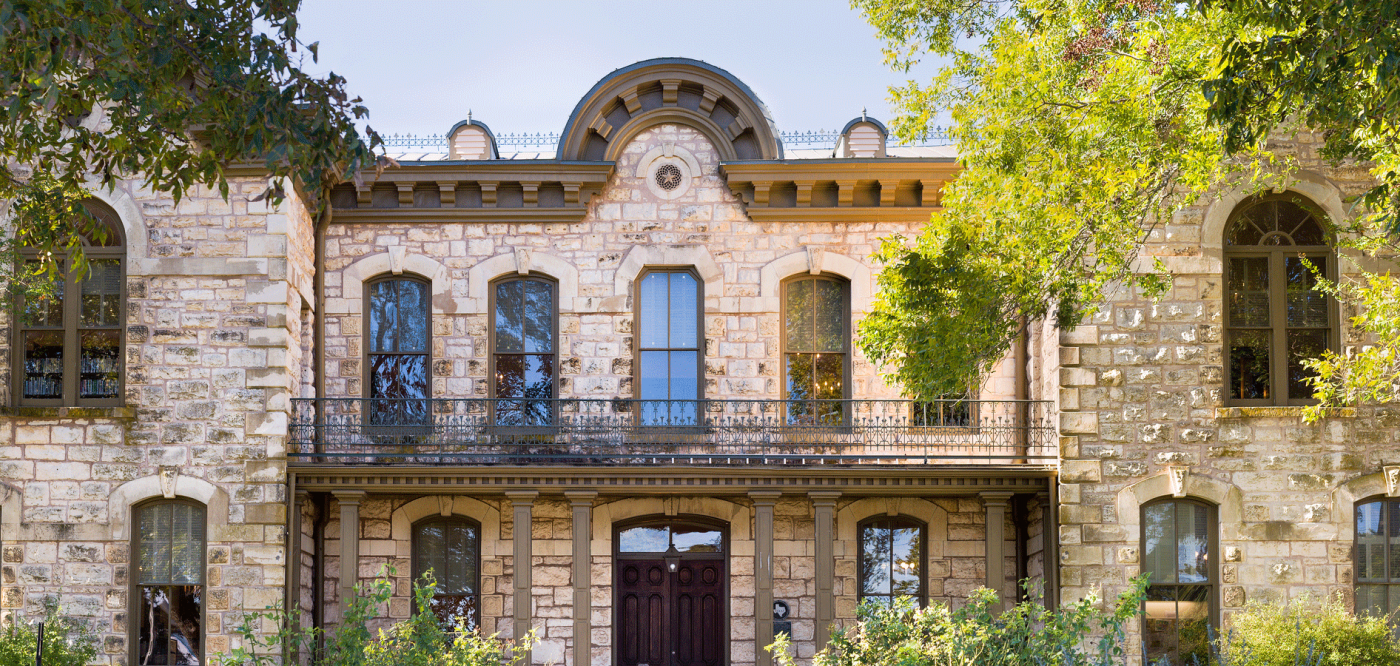 the pioneer memorial library in fredericksburg, texas. the building has two floors built with limestone in a romanesque revival style.
