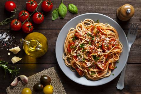 Italian Food spaghetti served in garlic butter sauce with cherry tomatoes, spinach and parmesean